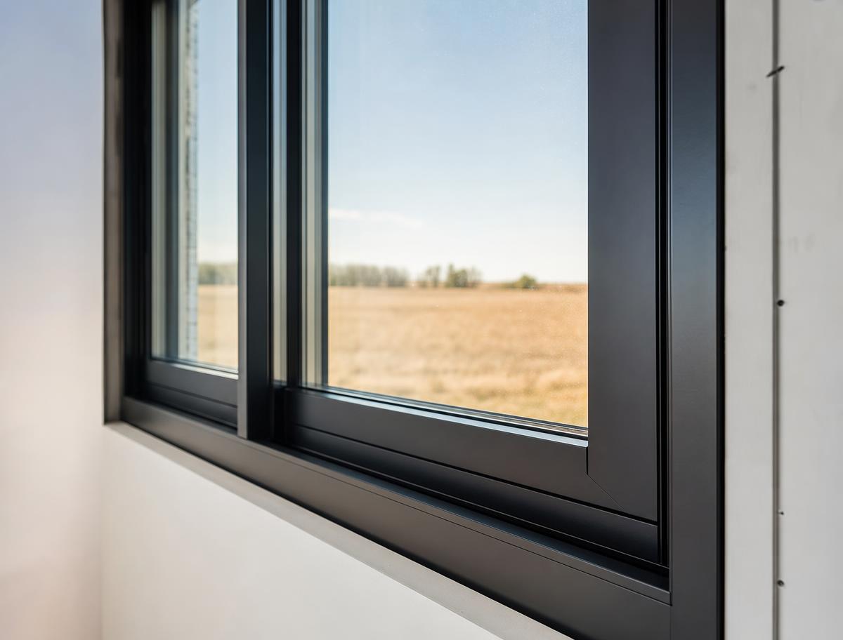 Modern black-framed window with a prairie view, no people